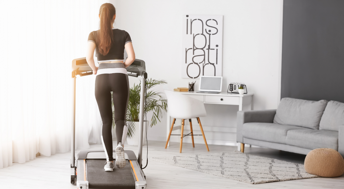 Imagem decorativa de uma modelo fazendo atividade física em uma esteira em casa, representando os aparelhos fitness silenciosos